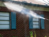 Spray,Of,Water,On,Siding,And,Brick,Work,On,The