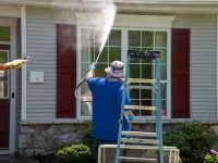 A,Man,Using,A,Power,Washer,To,Clean,The,Windows